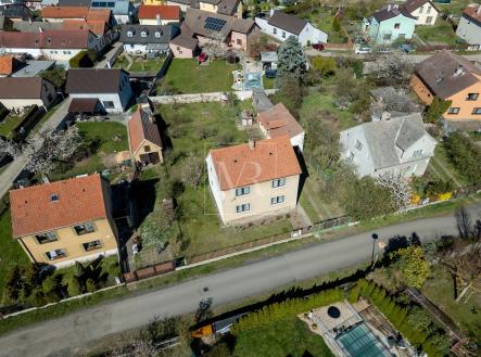 Letecký pohled na rezidenční čtvrť se zahradami a rodinnými domy, každý s tradiční střechou a zelení kolem. | Prodej - dům/vila, 127 m²