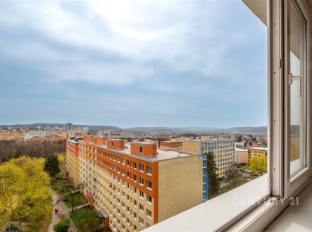 Výhled z okna na panoramatické město, moderní okolí, panelové domy s barevnými fasádami, svěží zeleň v okolí. | Pronájem bytu, 2+kk, 41 m²