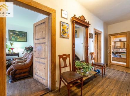 Chodba s dřevěnou podlahou a dveřmi, vintage nábytek, dekorativní zrcadlo, přístup k obývacímu pokoji, historický styl interiéru. | Prodej - chata/rekreační objekt, 183 m²