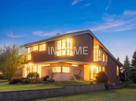 Moderní rodinný dům s cihlovou fasádou a velkými okny, prostorná zahrada a osvětlené interiéry vytvářejí elegantní a útulný vzhled | Prodej - dům/vila, 329 m²