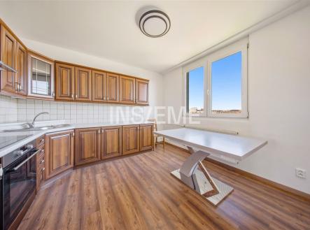 Moderní kuchyň s dřevěnými skříňkami, parketovou podlahou a velkými okny nabízí světlý a prostorný interiér vhodný pro rodinné vaření. | Prodej bytu, 2+1, 57 m²