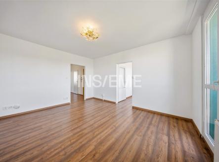 Světlý obývací pokoj s parketovou podlahou, velkými okny a moderním osvětlením. Prostor nabízí moderní design a příjemnou atmosféru. | Prodej bytu, 2+1, 57 m²