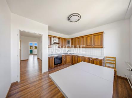 Prostorná kuchyň s dřevěnými skříňkami, moderními spotřebiči a parketovou podlahou, vedlejší světlý obývací pokoj s velkým oknem. | Prodej bytu, 2+1, 57 m²