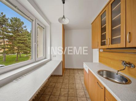 Kuchyň s velkými okny, dlažbou a vestavěnými skříněmi, moderní design a světlé prostředí. | Prodej bytu, 3+1, 73 m²