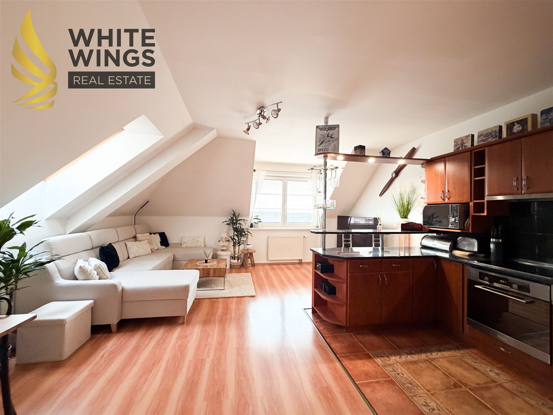 Podkrovní obývací pokoj s moderní kuchyní, parketová podlaha, vestavěné skříně, světlý interiér s velkými okny a elegantním designem