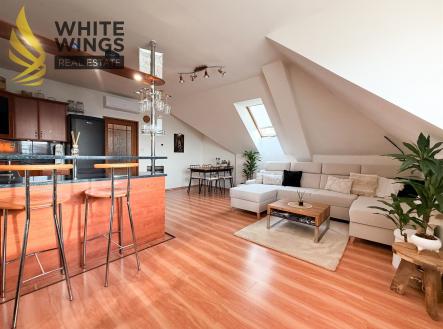 Světlý obývací pokoj s parketovou podlahou, moderní sedací soupravou a velkými střešními okny, stylový interiér a prostorný obývací prostor. | Prodej bytu, 3+kk, 87 m²