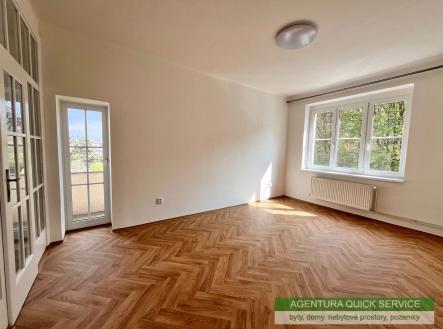 Světlý obývací pokoj s parketovou podlahou, velká okna poskytují výhled do zahrady, moderní interiér s prosklenými dveřmi na balkón | Pronájem bytu, 3+1, 67 m²