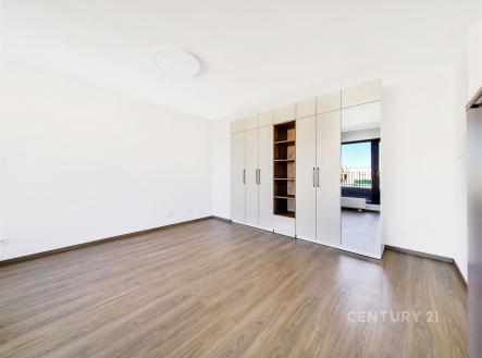 Světlá ložnice s parketovou podlahou, vestavěné skříně a velká okna. Moderní prostor s kvalitním designem a čistými liniemi. | Pronájem bytu, 1+kk, 31 m²