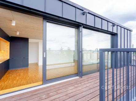 Velký balkon s dřevěnou podlahou sousedí s moderním obývacím pokojem. Velká okna zajišťují dostatek světla, parketová podlaha v interiéru. | Prodej bytu, 4+kk, 121 m²