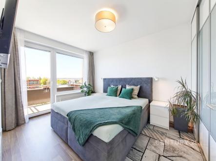 Prostorná ložnice s moderním designem, parketová podlaha, velká okna, světlá atmosféra, vestavěné skříně, elegantní dekorace. | Prodej bytu, 2+kk, 60 m²