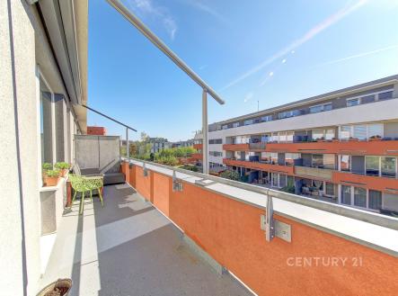 Prostorný balkon s betonovou podlahou a moderním zábradlím nabízí otevřený výhled, ideální pro relaxaci na slunných dnech. | Prodej bytu, 2+kk, 60 m²