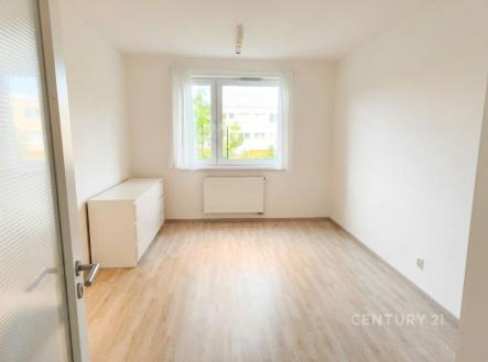 Světlá ložnice s parketovou podlahou, velká okna nabízejí dostatek přirozeného světla, moderní povrchy zdůrazňují čistý design. | Pronájem bytu, 1+kk, 34 m²